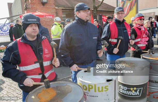 Dpatop - Siemens employees bang drums during a rally of IG Metall outside the Siemes Dynamo plant in Berlin, Germany, 27 February 2018. Photo: Paul...