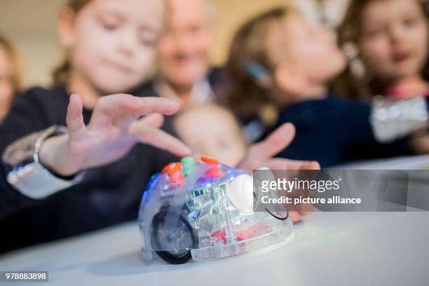 February 2018, Germany, Duesseldorf: Children at the nursery 'Seepferdchen' learn coding in a playful way. The children move a digital bug with...