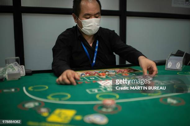 This picture taken on June 6, 2018 shows a student practicing baccarat at the Japan Casino School in Tokyo. - Japan has long been viewed as the Holy...