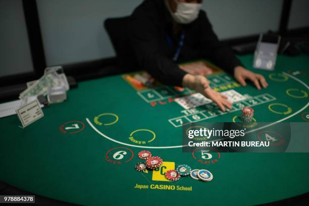 This picture taken on June 6, 2018 shows a student practicing baccarat at the Japan Casino School in Tokyo. - Japan has long been viewed as the Holy...