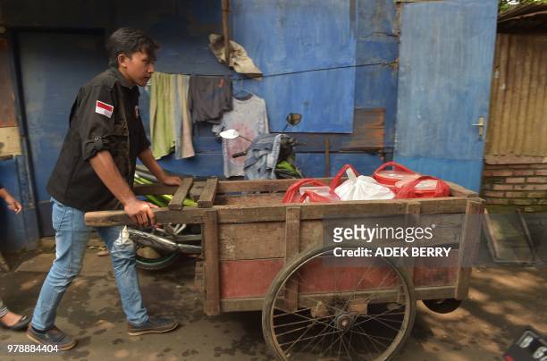 This picture taken on March 20, 2018 shows a volunteer of the programme "A Blessing to Share" wheeling a trolley as he distributes uneaten food in a...