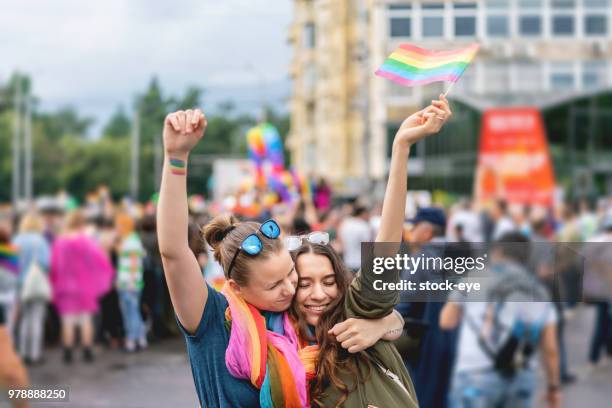 young adult female couple  at pride parade - pride parade stock pictures, royalty-free photos & images