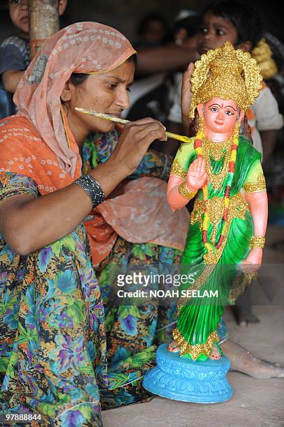An Indian artist gives final touches to a statue of Sita, wife of Hindu God Lord Rama, at her temporary tent in Hyderabad on March 20 on the...