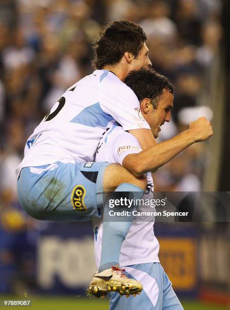Christopher Payne of Sydney celebrates with team mate Mark Bridge after Bridge scored a goal during the A-League Grand Final match between the...