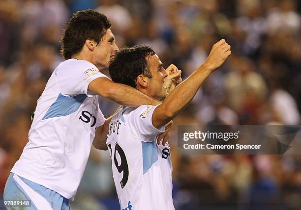 Christopher Payne of Sydney celebrates with team mate Mark Bridge after Bridge scored a goal during the A-League Grand Final match between the...