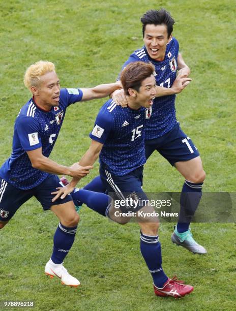 Yuya Osako of Japan celebrates with teammates Yuto Nagatomo and Makoto Hasebe after scoring Japan's second against Colombia during the second half of...