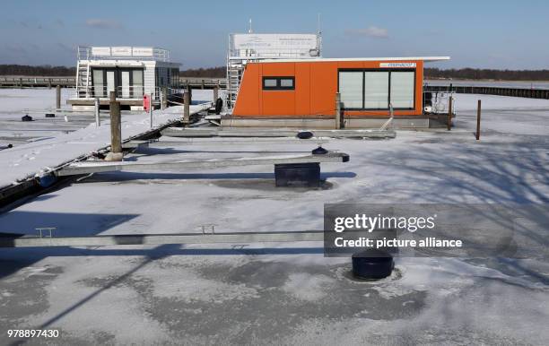 February 2018, Germany, Ribnitz-Damgarten: Swimming holiday homes are surrounded by ice at the Bodden harbour. According to the German Meteorological...