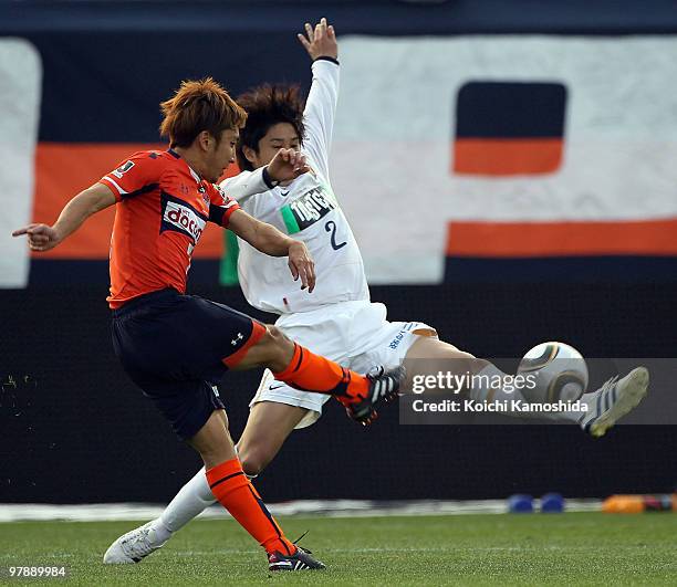 Tomoya Uchida of Omiya Ardija and Atsuto Uchida of Kashima Antlers compete for the ball during the J.League match between Omiya Ardija and Kashima...