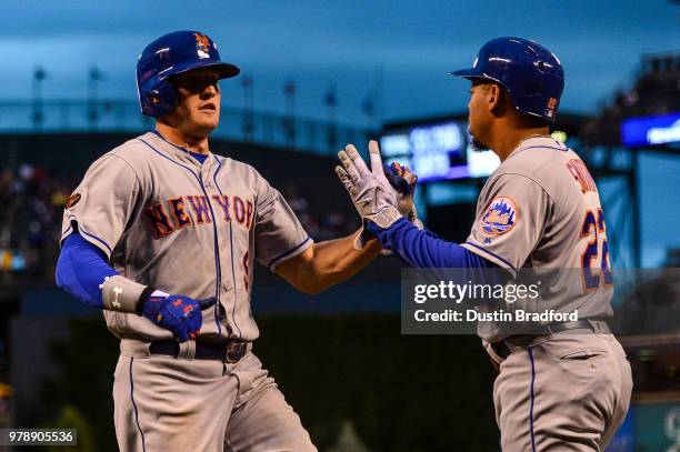 Brandon Nimmo of the New York Mets celebrates a first inning run scored with Dominic Smith at Coors Field on June 19, 2018 in Denver, Colorado.