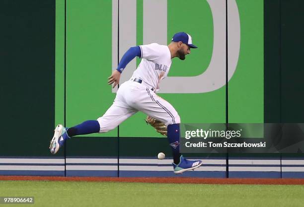 Kevin Pillar of the Toronto Blue Jays cannot hold on to the ball in the sixth inning during MLB game action as Freddie Freeman of the Atlanta Braves...