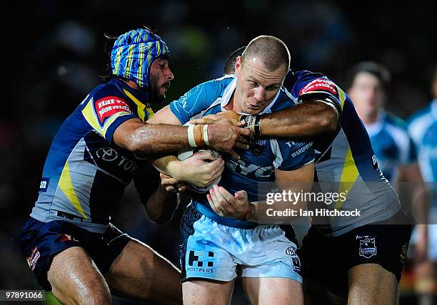 Luke Lewis of the Panthers is tackled by Johnathan Thurston and Antonio Kaufusi of the Cowboys during the round two NRL match between the North...