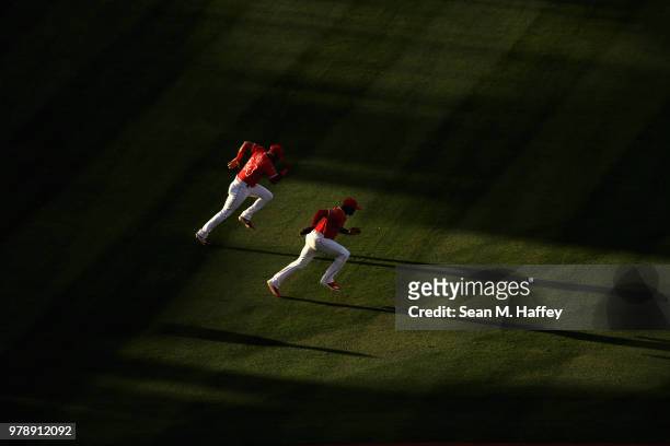 Chris Young and Justin Upton of the Los Angeles Angels of Anaheim warm up prior to a game against the Arizona Diamondbacks at Angel Stadium on June...