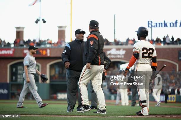 Manager Bruce Bochy of the San Francisco Giants argues with umpire Laz Diaz after Dan Straily of the Miami Marlins hit Buster Posey of the San...