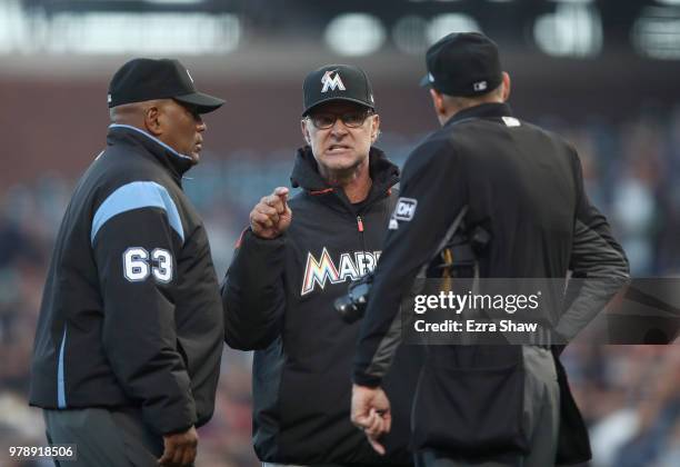 Manager Don Mattingly of the Miami Marlins argues with umpires Laz Diaz and Andy Fletcher after Dereck Rodriguez of the San Francisco Giants hit...