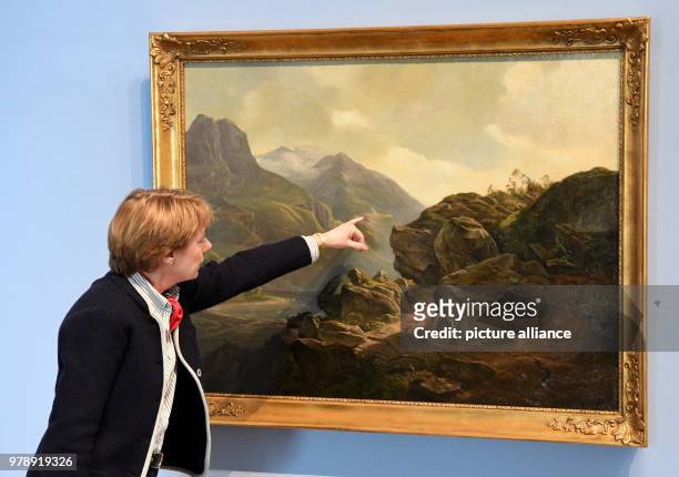 March 2018, Germany, Alkersum: The director of the museum, Ulrike Wolff-Thomsen, explains details in the painting "Norwegian mountain landscape by...