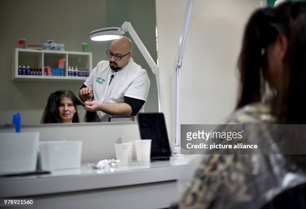 March 2018, Germany, Berlin: Naram Shakra prepares the treatment for killing the head lice of the customer Monika Beloch at the anti lice salon "Bye...