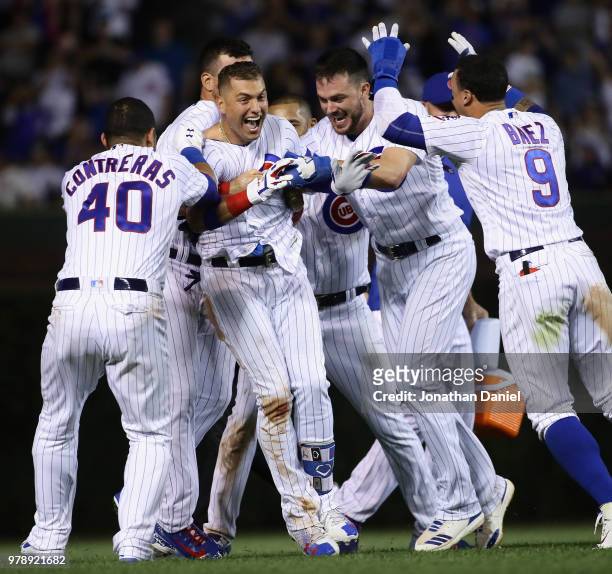 Albert Almora Jr. #5 of the Chicago Cubs is mobbed by teammates including Willson Contreras, Kris Bryant and Javier Baez after getting the...