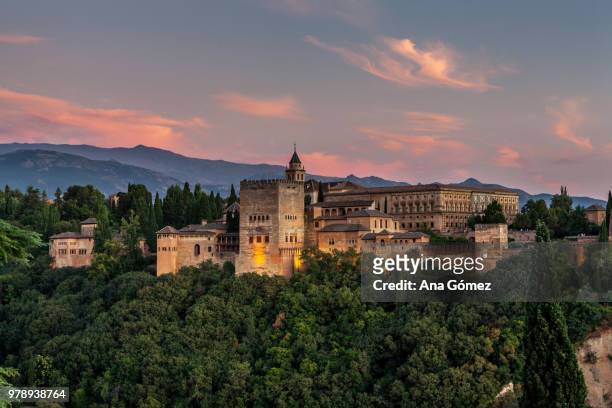 medieval palace and fortress of alhambra surrounded by forest at sunset, granada, andalusia, spain - granada spain landmark stock pictures, royalty-free photos & images