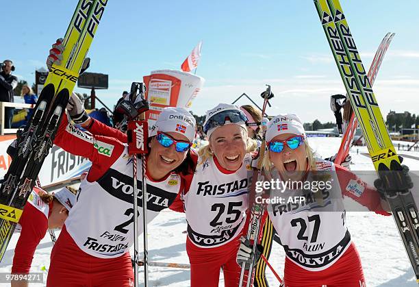 Norway's winning trio, winner Marit Bjoergen , second-placed Kristin Steira and third-placed Therese Johaug, pose in the finish area of the nordic...