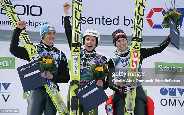 Gregor Schlierenzauer of Austria , Simon Ammann of Switzerland and Anders Jacobsen of Norway celebrate on the podium after the individual event of...