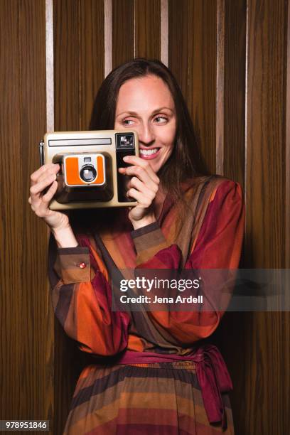 retro 1970s woman holding camera - funny photographer studio stock-fotos und bilder