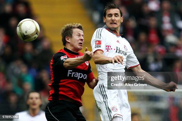 Miroslav Klose of Muenchen jumps for a header with Christoph Spycher of Frankfurt during the Bundesliga match between Eintracht Frankfurt and Bayern...