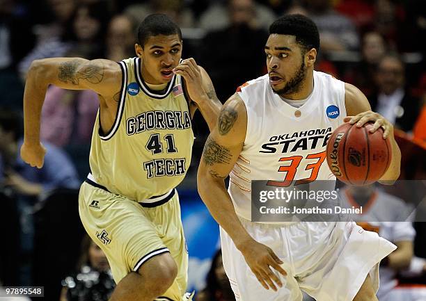 Marshall Moses of the Oklahoma State Cowboys moves the ball against Glen Rice Jr. #41 of the Georgia Tech Yellow Jackets in the first half during the...