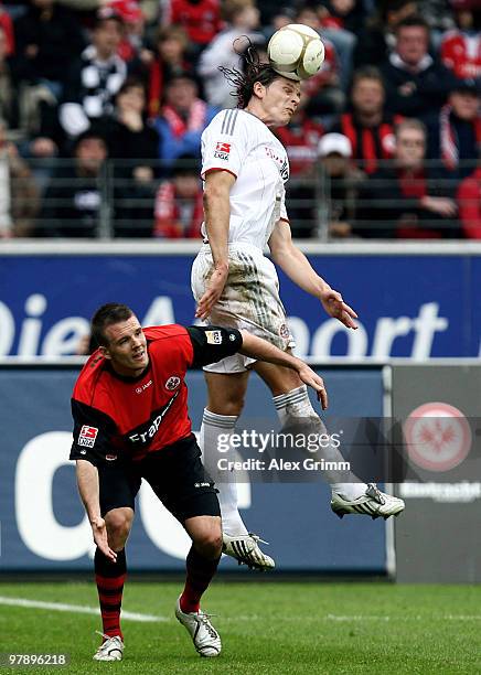 Daniel van Buyten of Muenchen outjumps Alexander Meier of Frankfurt during the Bundesliga match between Eintracht Frankfurt and Bayern Muenchen at...