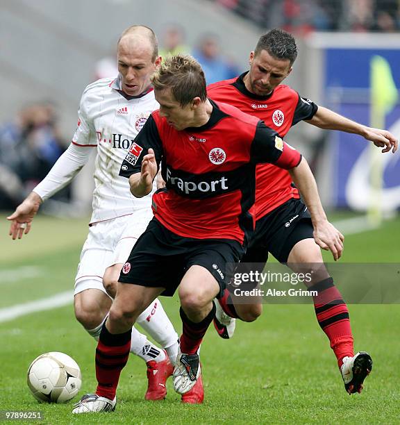 Arjen Robben of Muenchen is challenged by Christoph Spycher and Benjamin Koehler of Frankfurt during the Bundesliga match between Eintracht Frankfurt...