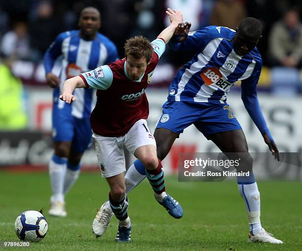 Mohamed Diame of Wigan is challenged by Wade Elliott of Burnley during the Barclays Premier League match between Wigan Athletic and Burnley at the...