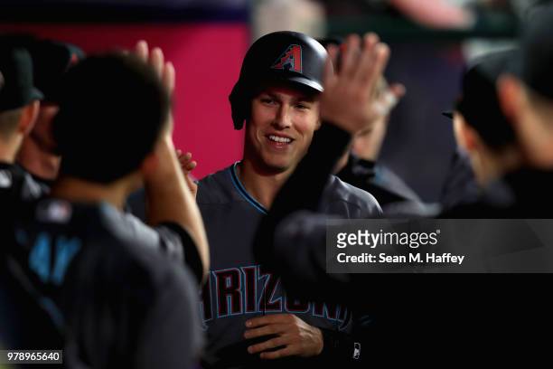 Jake Lamb is congraulated in the dugout after scoring on an RBI double by David Peralta of the Arizona Diamondbacks during the fifth inning of a game...