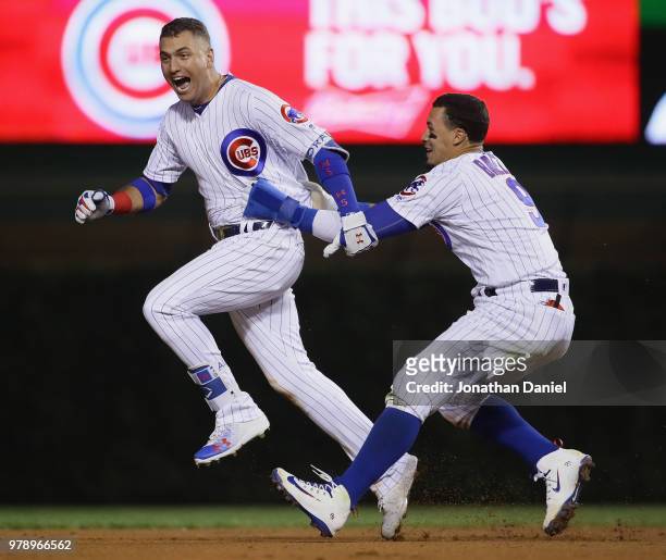 Albert Almora Jr. #5 and Javier Baez of the Chicago Cubs celebrate after A;mora got the game-winning hit in the 10th inning against the Los Angeles...