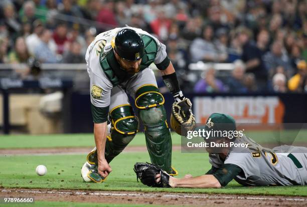 Jonathan Lucroy of the Oakland Athletics and Paul Blackburn can't make the catch on a bunt single hit by Cory Spangenberg of the San Diego Padres...