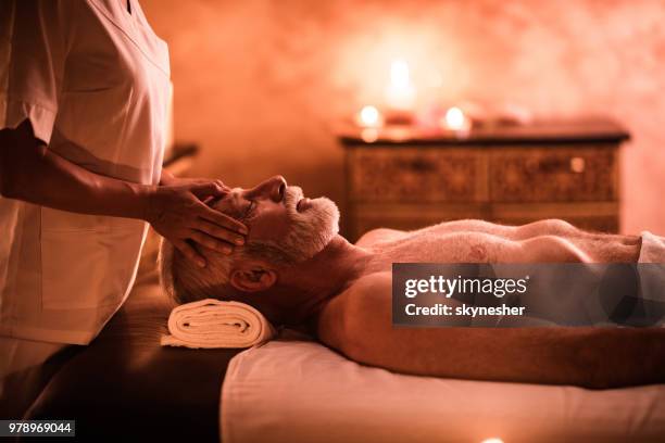 uomo maturo che riceve un massaggio alla testa presso la spa. - head massage foto e immagini stock