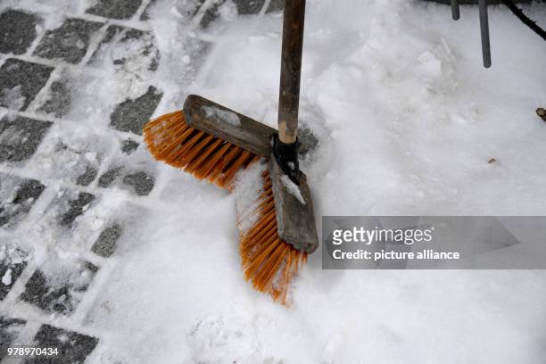 Dpatop - 01 March 2018, Germany, Wyk: A snapped broom left standing in the snow on a pavement on the island of Foehr. The north sea island has not...