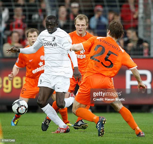 Papiss Cisse of Freiburg battles for the ball with Andreas Ivanschitz of Mainz during the Bundesliga match between SC Freiburg and FSV Mainz 05 at...