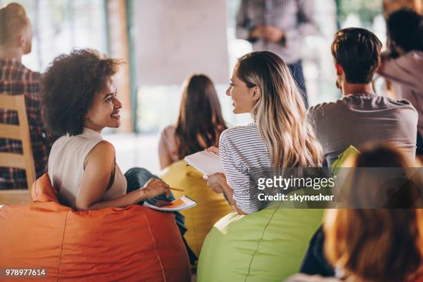 happy creative women talking during a business presentation at casual office. - training bean bag stock pictures, royalty-free photos & images