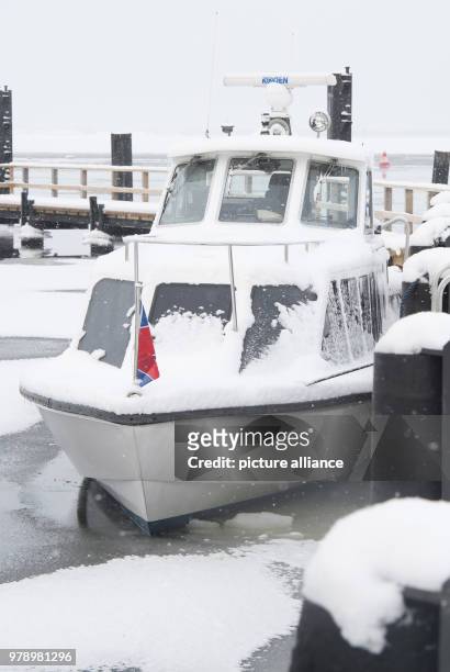 March 2018, Germany, Schaprode: A water taxi is surrounded by ice at the port. The Hiddensee shipping company is driving according to a special ice...