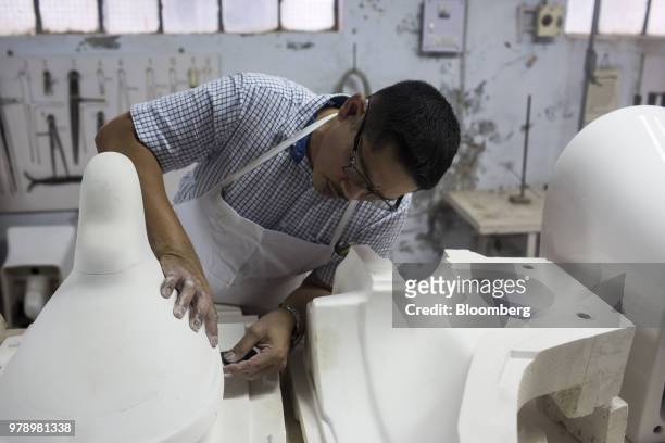 An employees works on a mold in a workshop at the HSIL Ltd. Factory in Bahadurgarh, Haryana, India, on Monday, June 11, 2018. Indian Prime Minister...