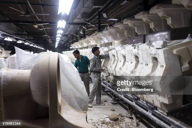 Employees check a line of toilet bowl battery molds at the HSIL Ltd. Factory in Bahadurgarh, Haryana, India, on Monday, June 11, 2018. Indian Prime...
