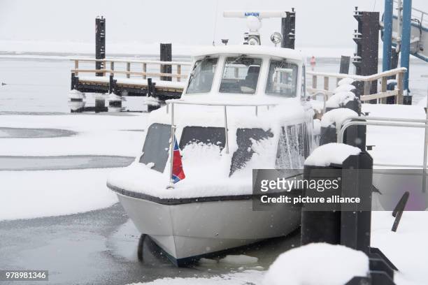 March 2018, Germany, Schaprode: A water taxi is surrounded by ice at the port. The Hiddensee shipping company is driving according to a special ice...