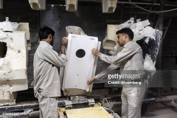 Employees remove a section from a toilet bowl battery mold at the HSIL Ltd. Factory in Bahadurgarh, Haryana, India, on Monday, June 11, 2018. Indian...
