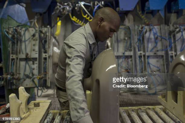 An employee places a cast wash basin on a workbench at the HSIL Ltd. Factory in Bahadurgarh, Haryana, India, on Monday, June 11, 2018. Indian Prime...