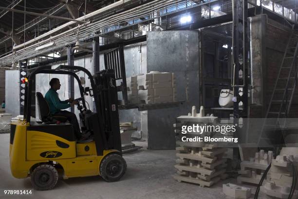 An employee uses a forklift to transport sanitaryware molds into a drying room at the HSIL Ltd. Factory in Bahadurgarh, Haryana, India, on Monday,...