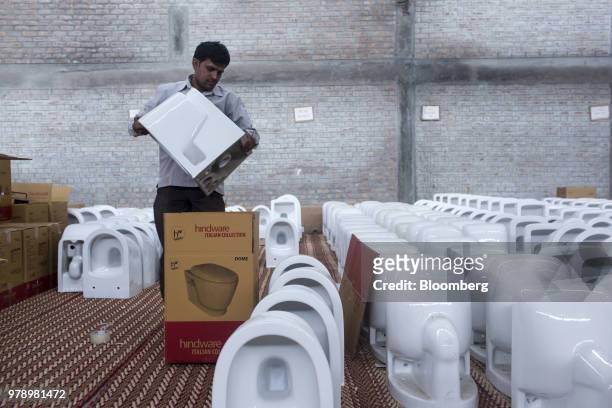 An employee packs a Dome toilet bowl from the Hindware Italian Collection at the HSIL Ltd. Factory in Bahadurgarh, Haryana, India, on Monday, June...
