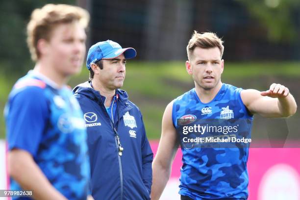 Kangaroos head coach Brad Scott listens to Shaun Higgins of the Kangaroos during a North Melbourne Kangaroos AFL training session at Arden Street on...