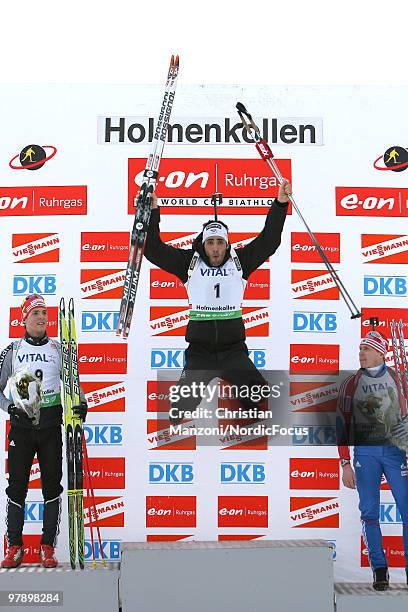 Simon Schempp of Germany and Ivan Tcherezov of Russia watch Martin Fourcade of France jumping on the podium after the men's pursuit in the E.On...