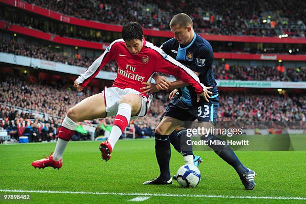 Samir Nasri of Arsenal is challenged by Fabio Daprela of West Ham United during the Barclays Premier League match between Arsenal and West Ham United...