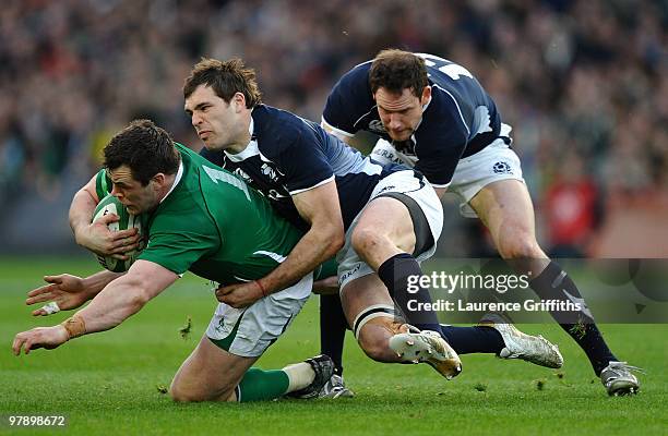Cian Healy of Ireland is tackled by Sean Lamont and Graeme Morrison of Scotland during the RBS Six Nations match between Ireland and Scotland at...
