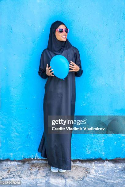 elegant woman in traditional clothes holding blue balloon - dish dash stock pictures, royalty-free photos & images